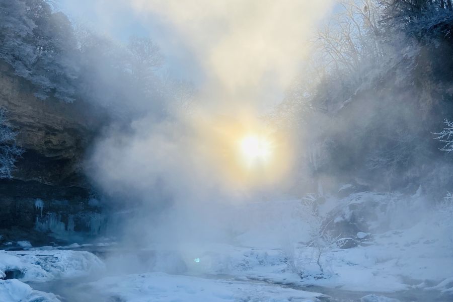 Sun peeking through the falls at Willow River State Park during a cold winter day! - Photo credit: DNR